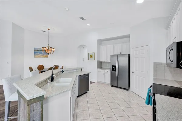 a kitchen with a sink refrigerator and microwave