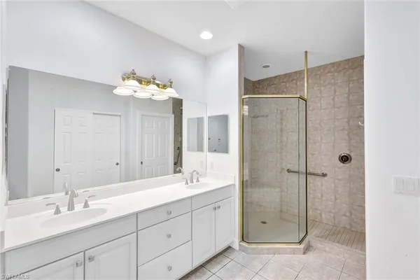a bathroom with a double vanity sink mirror and shower