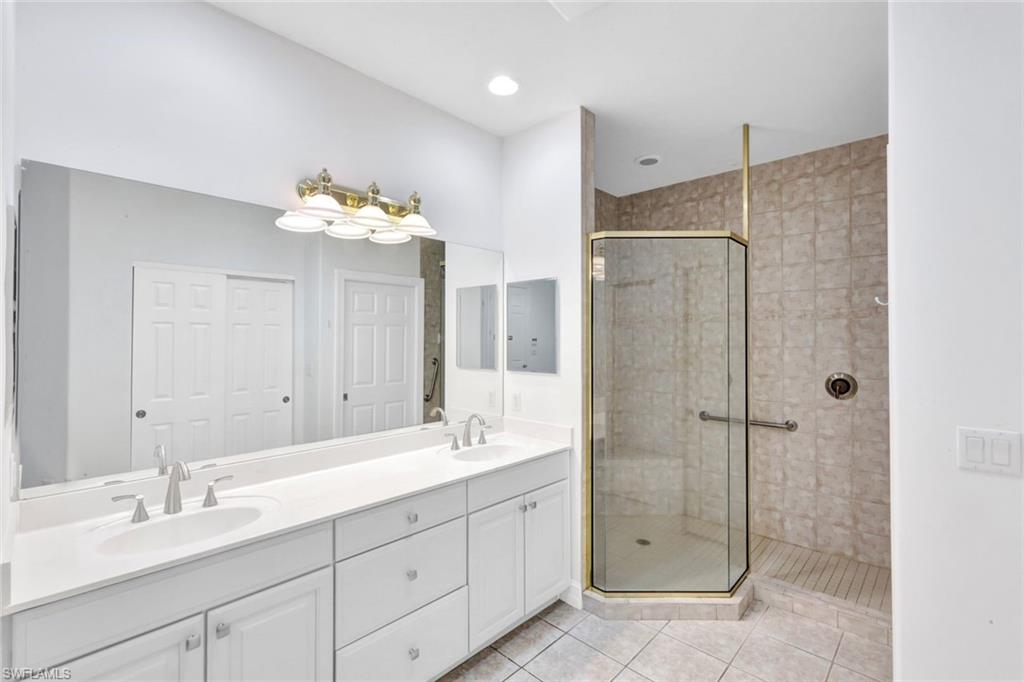 1277 Rialto Way, Unit 201 Naples, FL 34114 - Photo 16 of 46 a bathroom with a double vanity sink mirror and shower