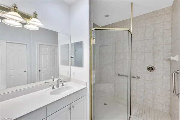 a bathroom with a shower sink vanity granite and mirror