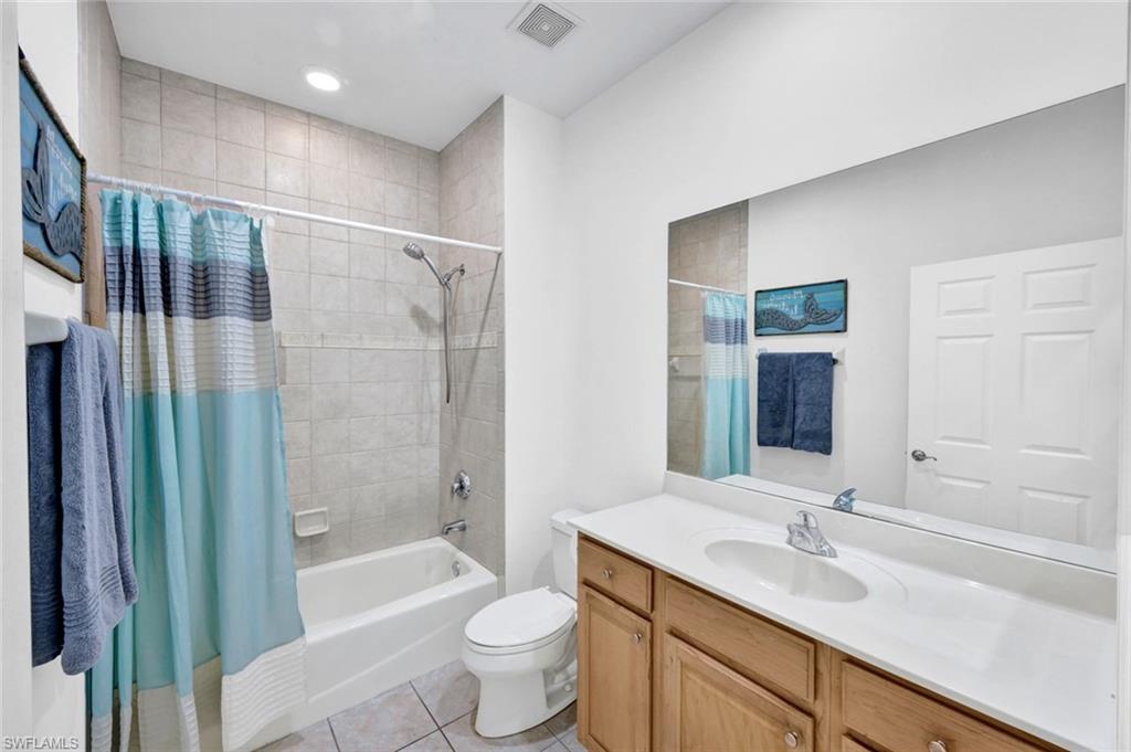 1277 Rialto Way, Unit 201 Naples, FL 34114 - Photo 19 of 46 a bathroom with a double vanity sink toilet mirror and bathtub