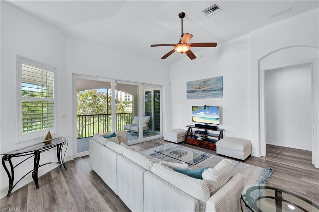 1277 Rialto Way, Unit 201 Naples, FL 34114 - Photo 4 of 46 a living room with furniture and a large window