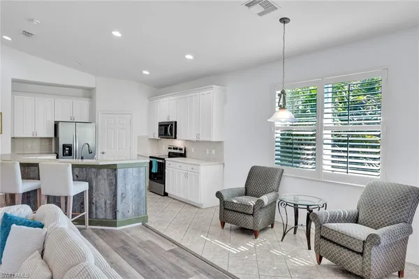 a living room with furniture flat screen tv and window