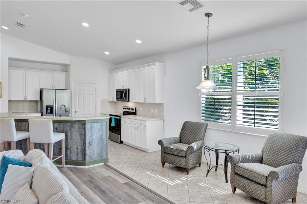 1277 Rialto Way, Unit 201 Naples, FL 34114 - Photo 6 of 46 a living room with furniture flat screen tv and window