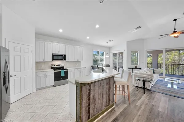 a kitchen with kitchen island granite countertop a sink appliances and cabinets