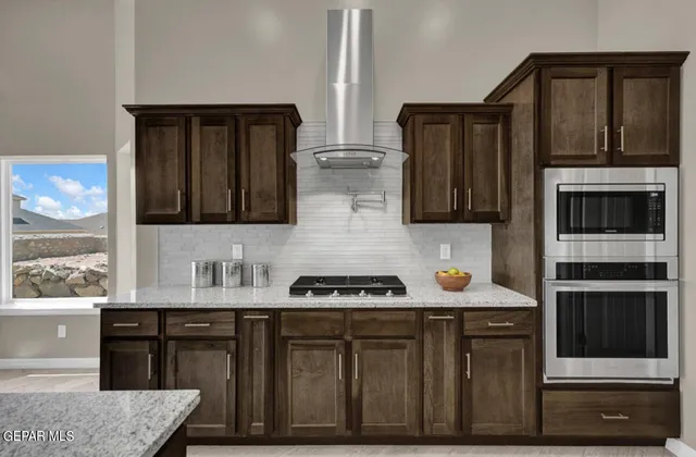 a kitchen with stainless steel appliances a stove and a microwave