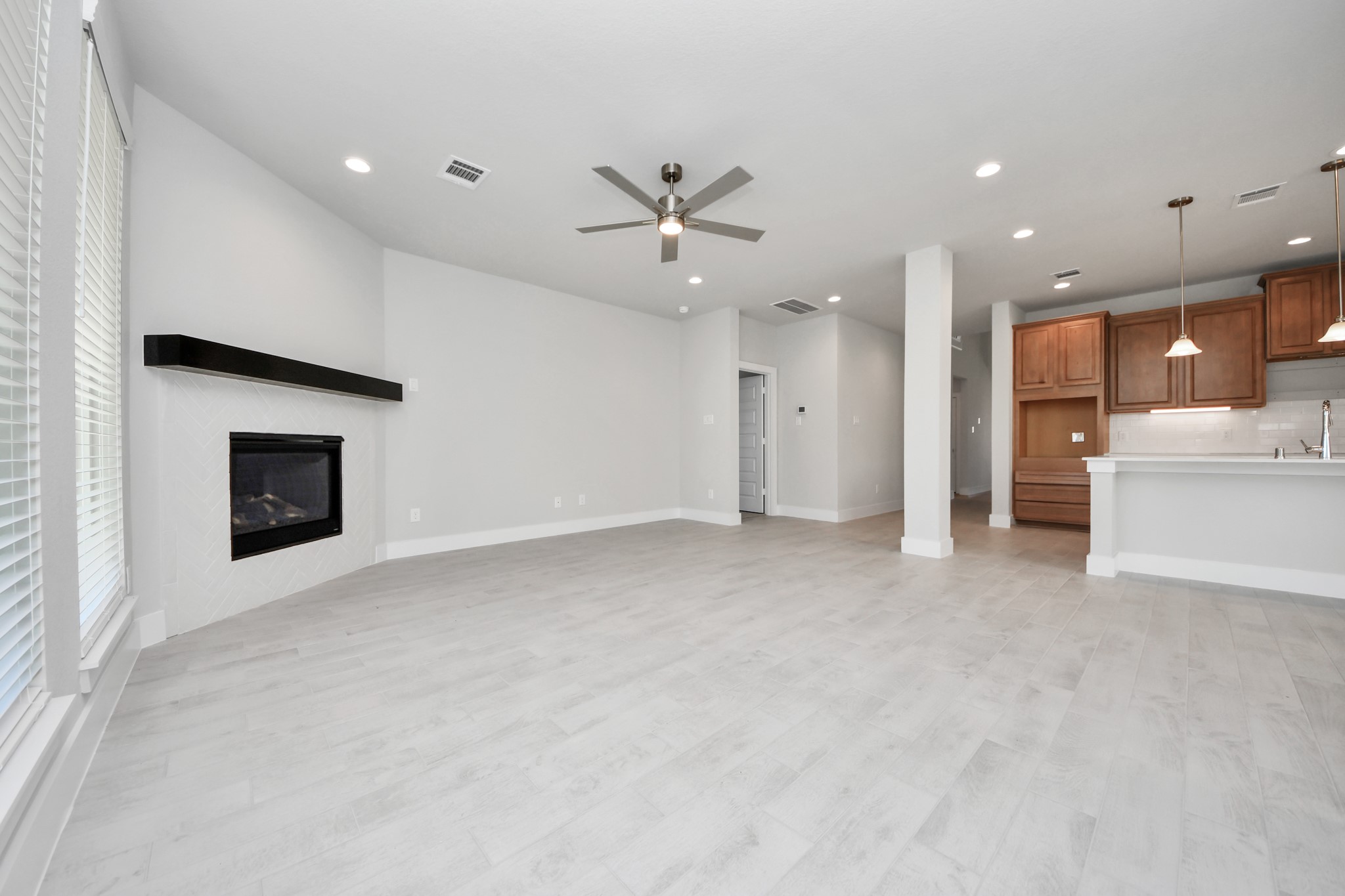 3102 Native Spg Drive Spring, TX 77373 - Photo 20 of 40 Relax and unwind in this inviting family room, illuminated by abundant natural light streaming in through tall windows, complemented by high ceilings and stunning flooring. Stay comfortable year-round with the gentle breeze from the ceiling fan, creating the perfect atmosphere for family gatherings. Sample photo of completed home with similar floor plan. Actual colors and selections may vary.