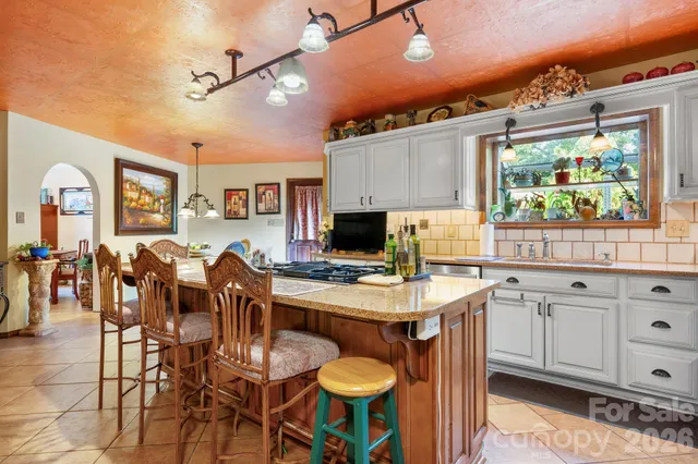 a kitchen with stainless steel appliances a dining table and chairs with wooden floor