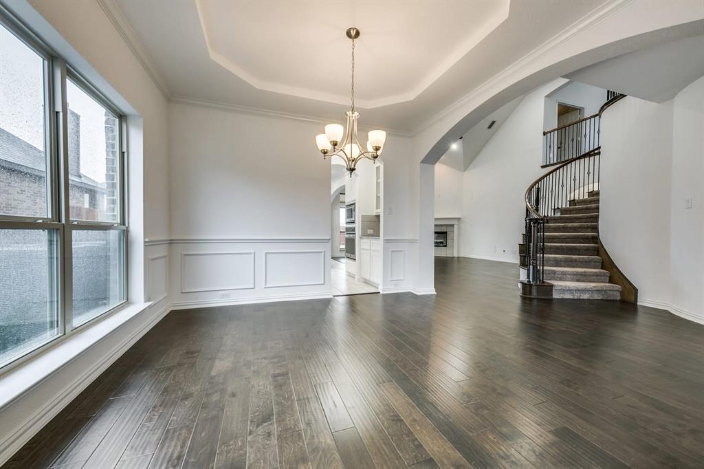 104 Sweetleaf Drive Red Oak, TX 75154 - Photo 19 of 36 This inviting interior features dark hardwood flooring, wainscoting along the walls, and a decorative ceiling with a chandelier