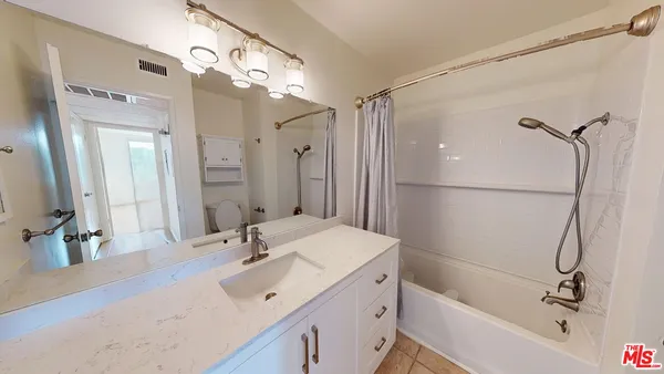 a bathroom with a tub sink and mirror