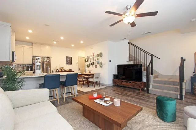 a living room with furniture a flat screen tv and a table