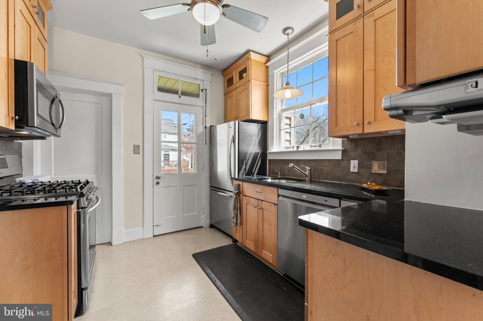 503 Kingston Road Baltimore, MD 21229 - Photo 4 of 15 a kitchen with stainless steel appliances granite countertop a stove refrigerator and a microwave