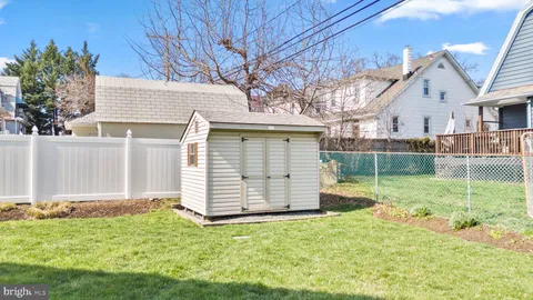a view of backyard of house with wooden fence