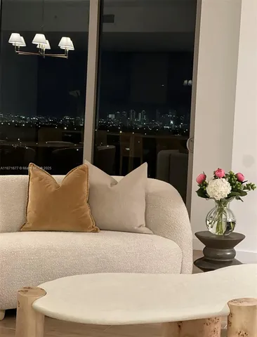 a living room with furniture flowerpot and a flat screen tv