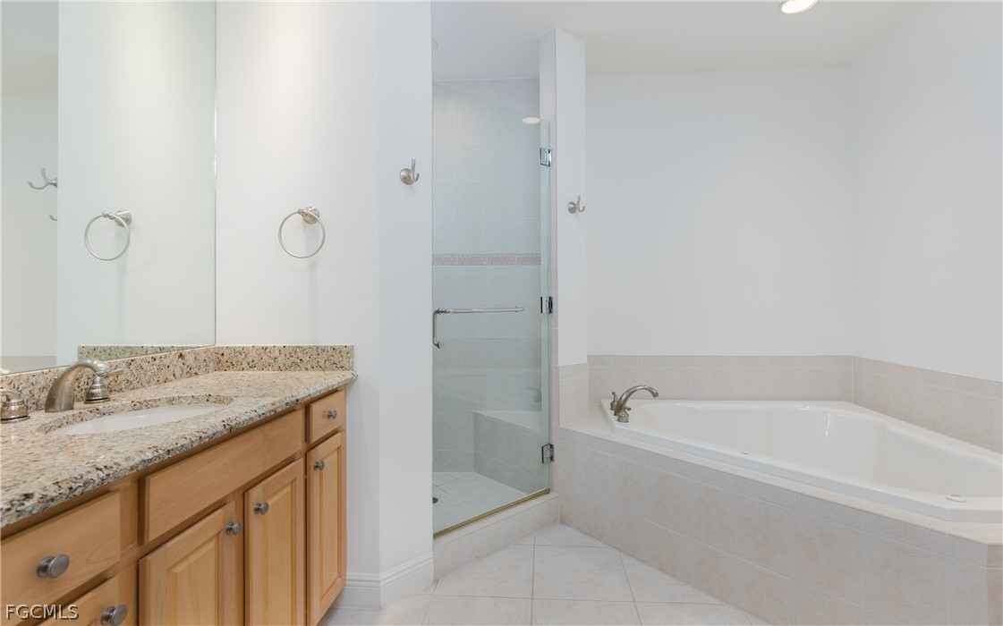 2090 West First Street, Unit J2510 Fort Myers, FL 33901 - Photo 15 of 50 a spacious bathroom with a granite countertop sink and a bathtub