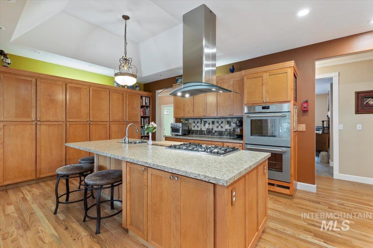 5184 North Greyloch Way Boise, ID 83704 - Photo 5 of 32 Open-concept kitchen featuring light wood cabinetry, a central island with a built-in gas cooktop, and light speckled countertops