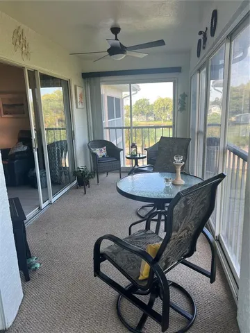 a living room with furniture a flat screen tv and a large window