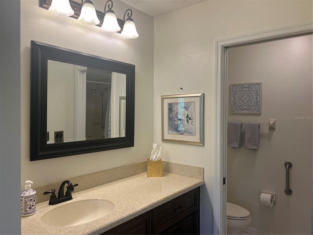 6501 Stone River Road, Unit 309 Bradenton, FL 34203 - Photo 26 of 33 a bathroom with a toilet a sink and mirror