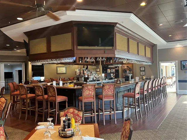 a dining hall with stainless steel appliances kitchen island granite countertop a dining table and chairs