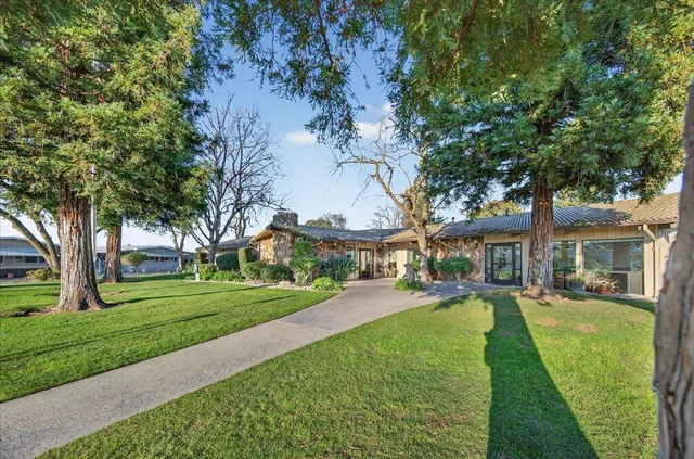 a living room with lots of furniture wooden floor and chandelier