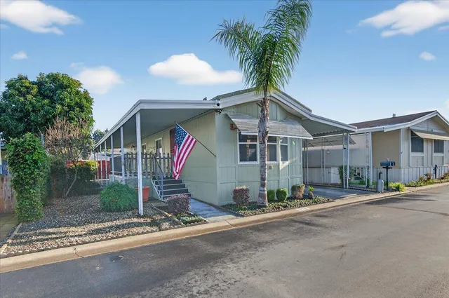 a view of a house with a yard and palm trees