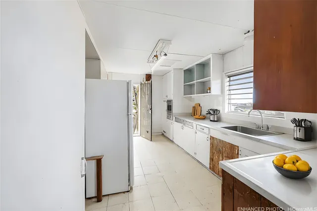 a large kitchen with a sink and dishwasher a stove with wooden floor
