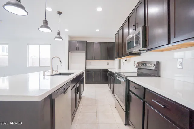 a kitchen with stainless steel appliances granite countertop a sink a counter space and cabinets