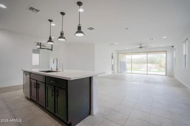 a kitchen with a stove a sink a window and chairs
