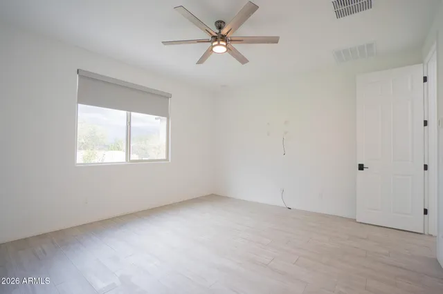 an empty room with fan and windows