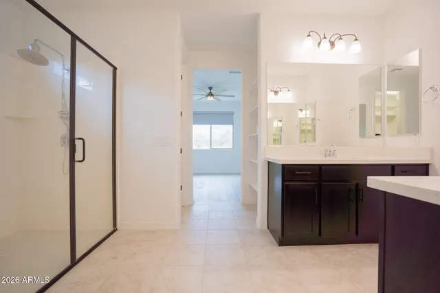 a bathroom with a double vanity sink a mirror and a shower