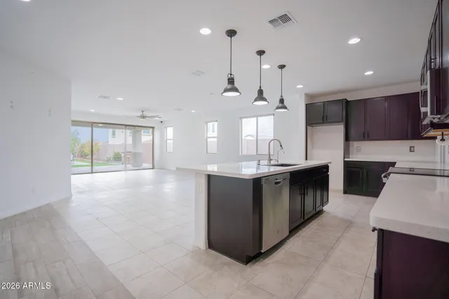 a large kitchen with stainless steel appliances kitchen island granite countertop a large counter top a stove a sink and a refrigerator