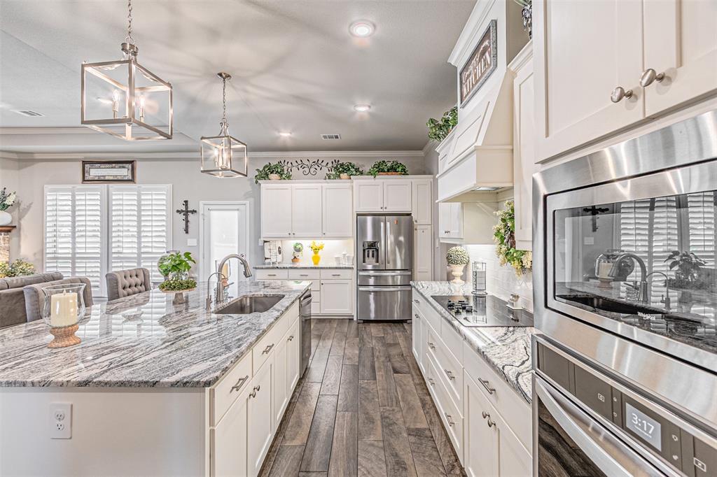 1009 Henry Way Springtown, TX 76082 - Photo 20 of 40 Kitchen with pendant lighting, a breakfast bar area, appliances with stainless steel finishes, white cabinetry, and light stone countertops