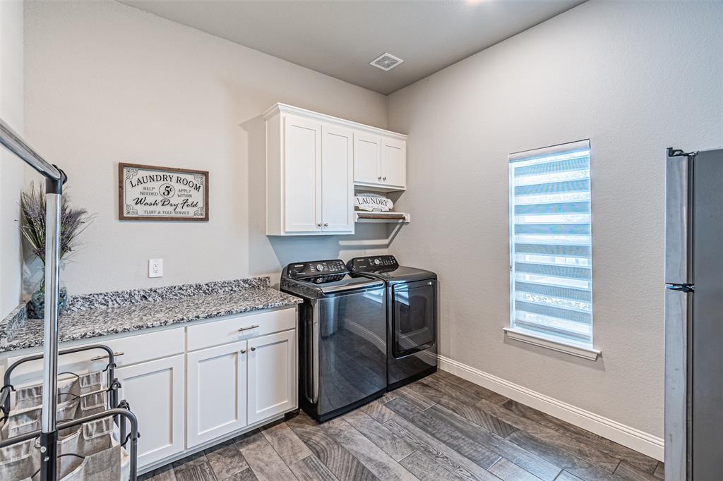 1009 Henry Way Springtown, TX 76082 - Photo 26 of 40 Laundry room with dark wood-type flooring, independent washer and dryer, and cabinet space