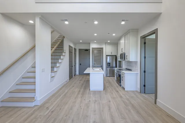 a open kitchen with white cabinets and stainless steel appliances