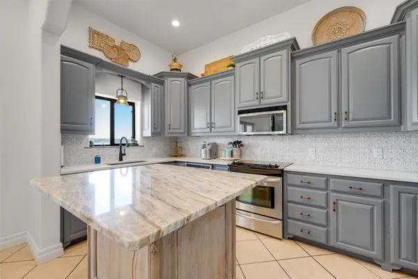 a kitchen with stainless steel appliances a stove refrigerator sink and cabinets