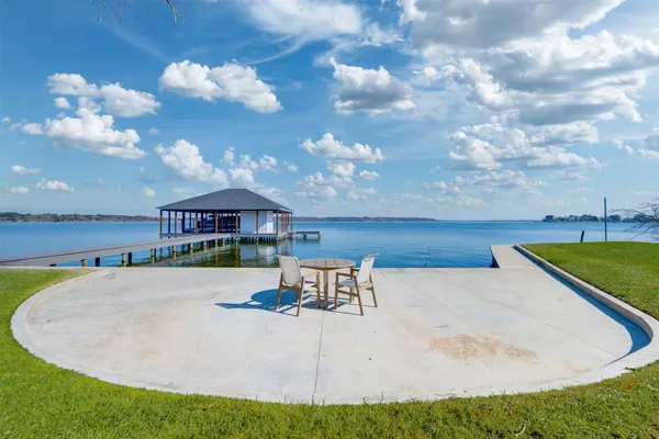 a view of a house with a yard from a lake view
