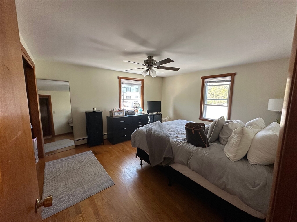 224 Berlin Street, Unit 2 Clinton, MA 01510 - Photo 2 of 5 a bedroom with a bed couch and windows