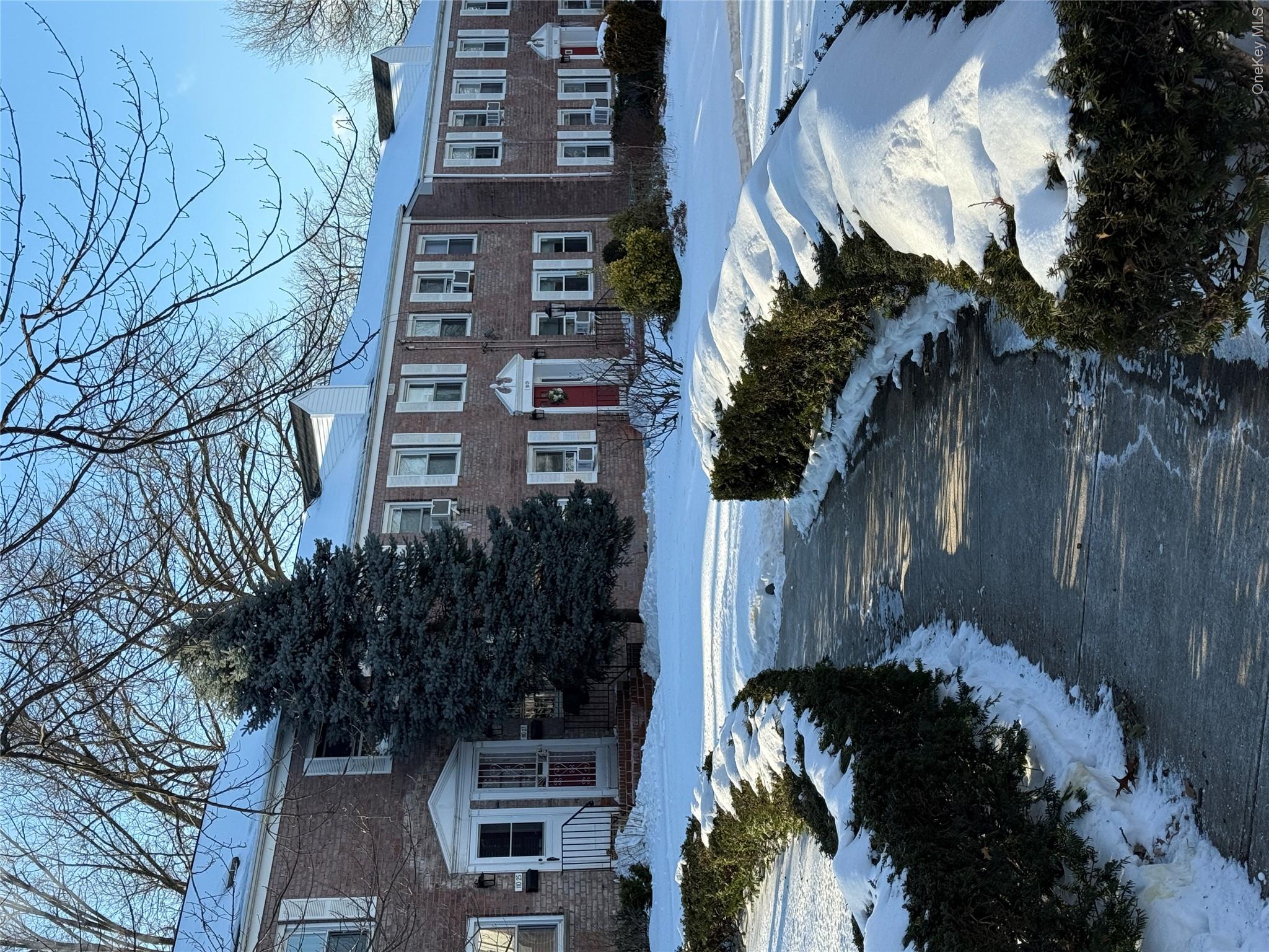 110-51 64th Road, Unit 25 Queens, NY 11375 - Photo 2 of 24 a view of a house with a yard covered with snow in the middle
