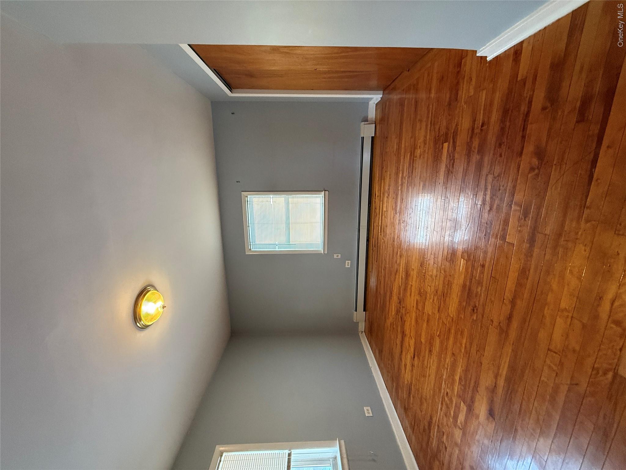 110-51 64th Road, Unit 25 Queens, NY 11375 - Photo 22 of 24 an empty room with wooden floor and windows