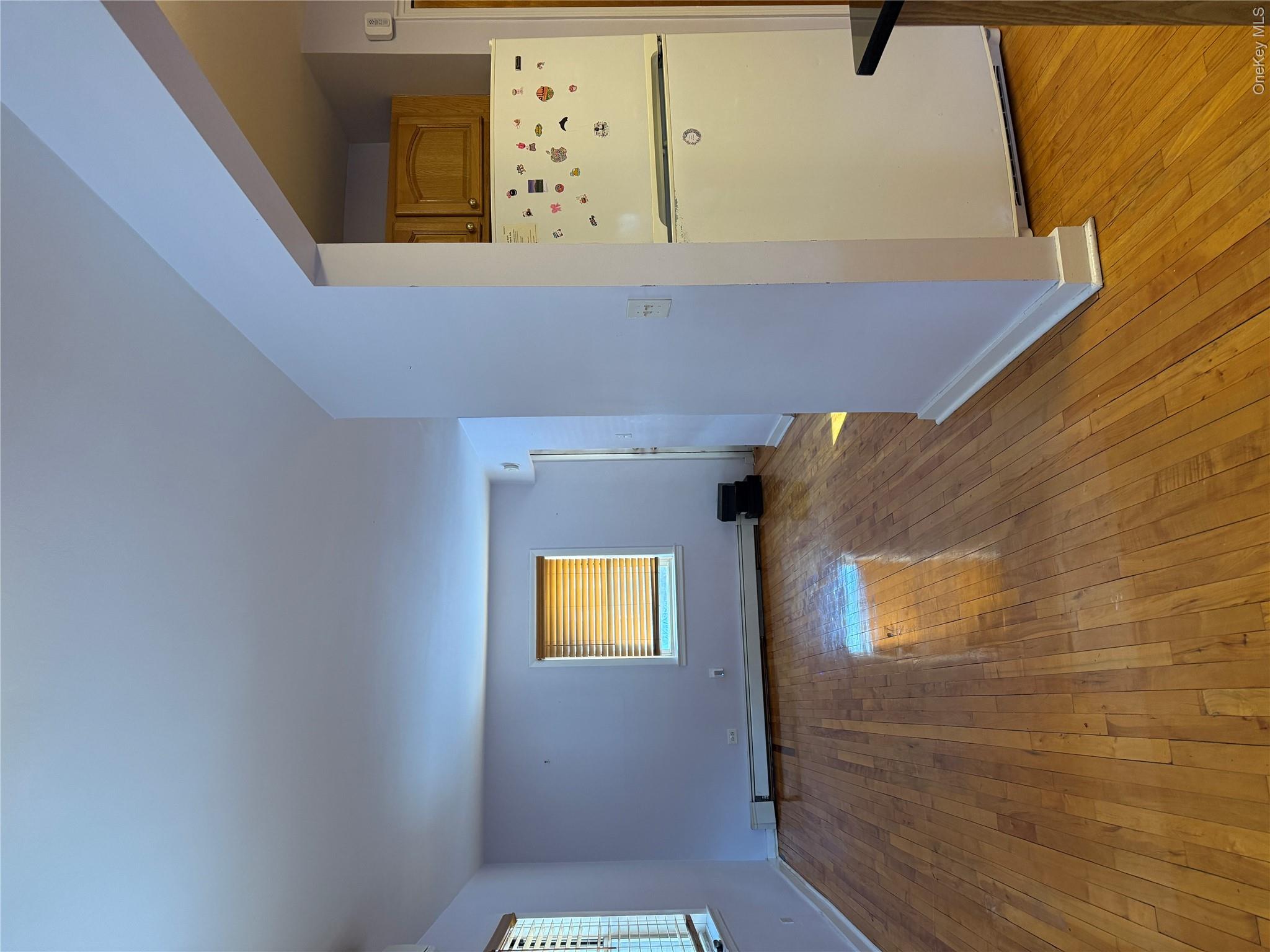 110-51 64th Road, Unit 25 Queens, NY 11375 - Photo 6 of 24 a view of an empty room with wooden floor and a kitchen