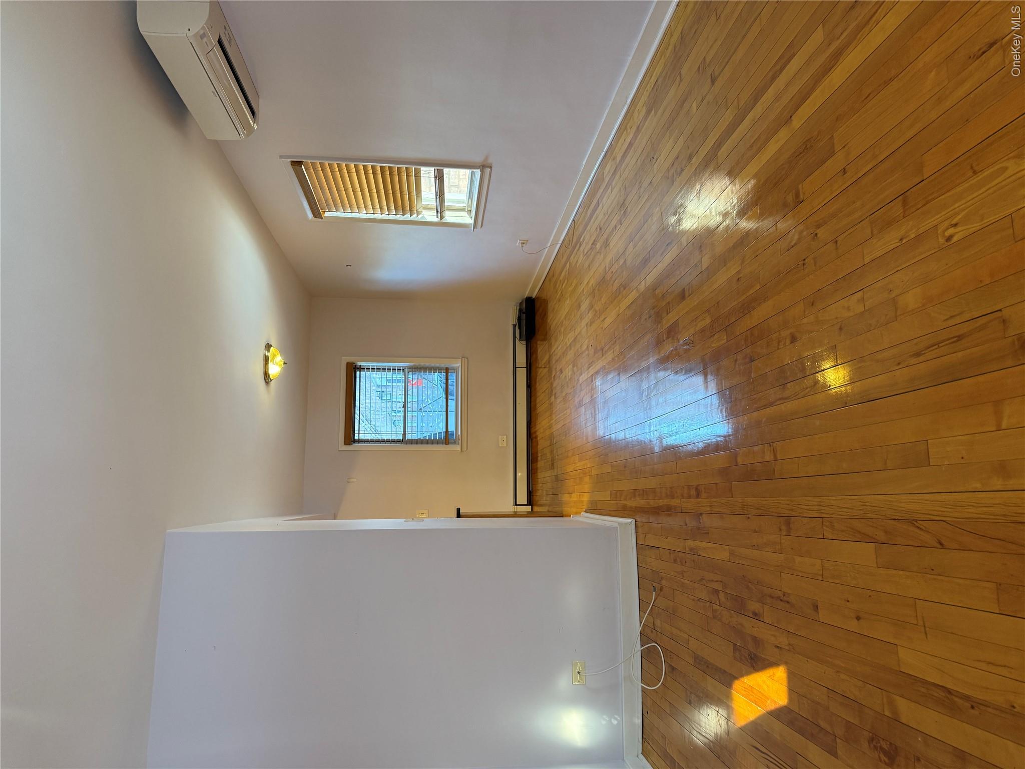 110-51 64th Road, Unit 25 Queens, NY 11375 - Photo 8 of 24 an empty room with wooden floor and windows