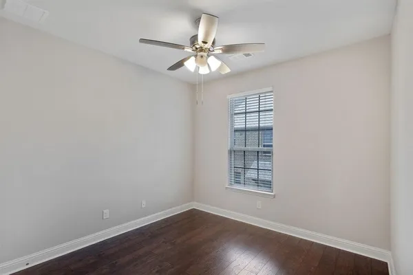 an empty room with a window and a ceiling fan