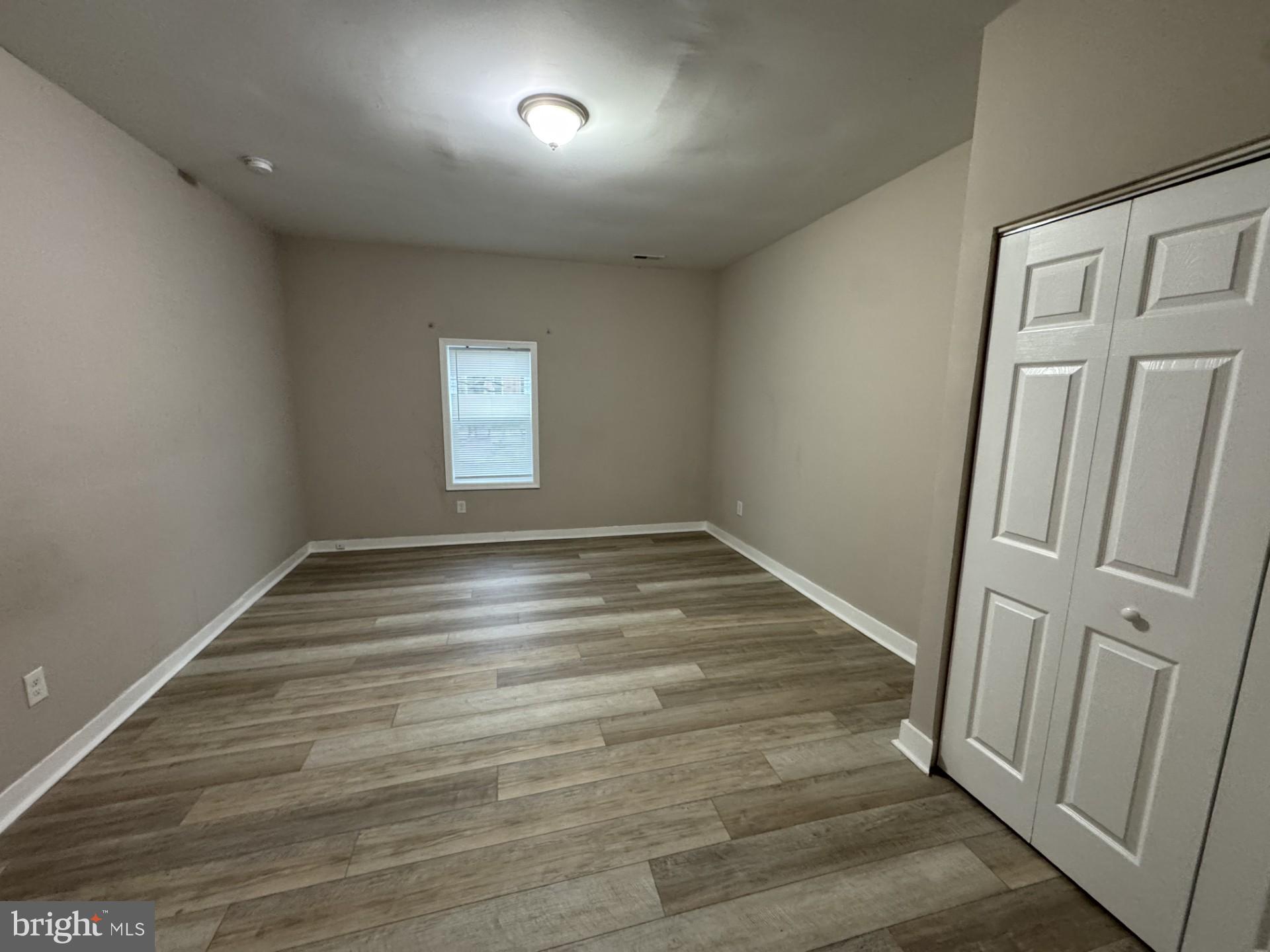 3920 Main Street, Unit A Trappe, MD 21673 - Photo 13 of 16 an empty room with wooden floor and window