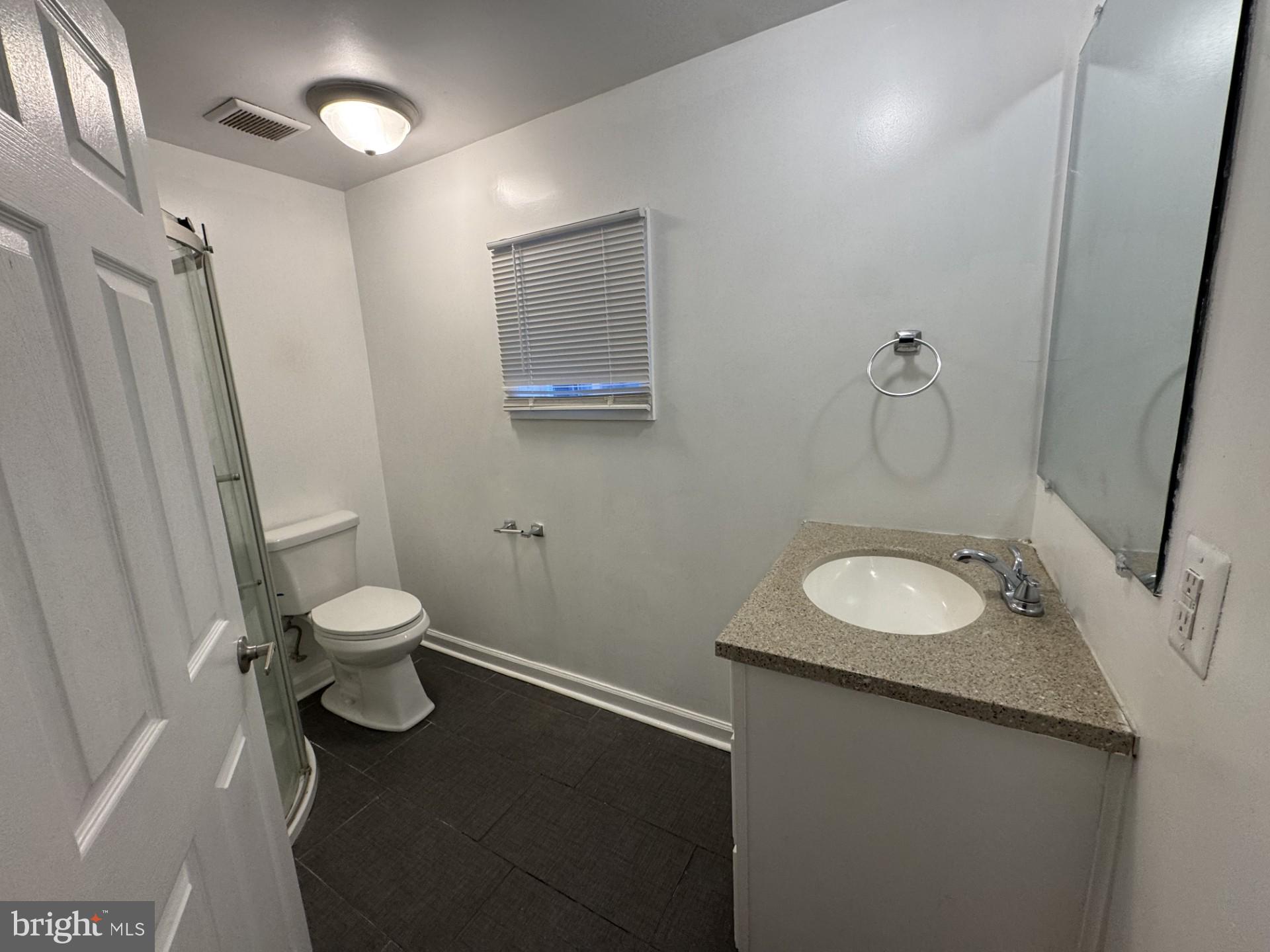 3920 Main Street, Unit A Trappe, MD 21673 - Photo 9 of 16 a bathroom with a granite countertop sink toilet and shower