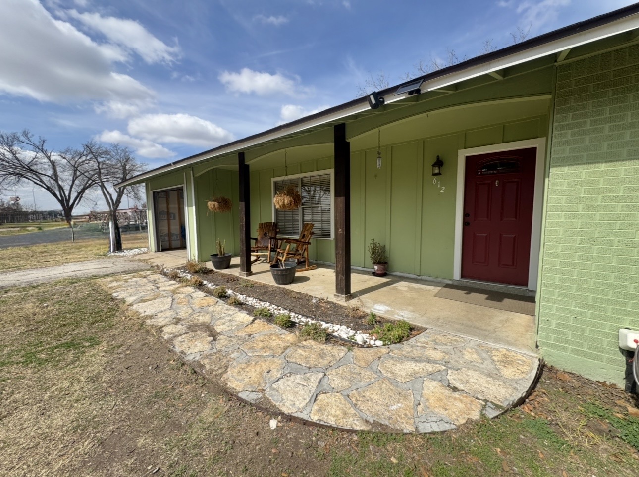 612 Cardinal Street Elgin, TX 78621 - Photo 2 of 28 View of exterior entry with board and batten siding, brick siding, and covered porch