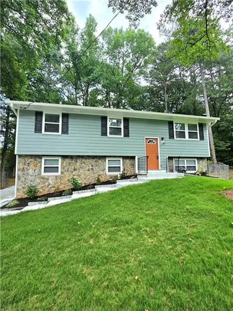 a front view of a house with a yard and trees