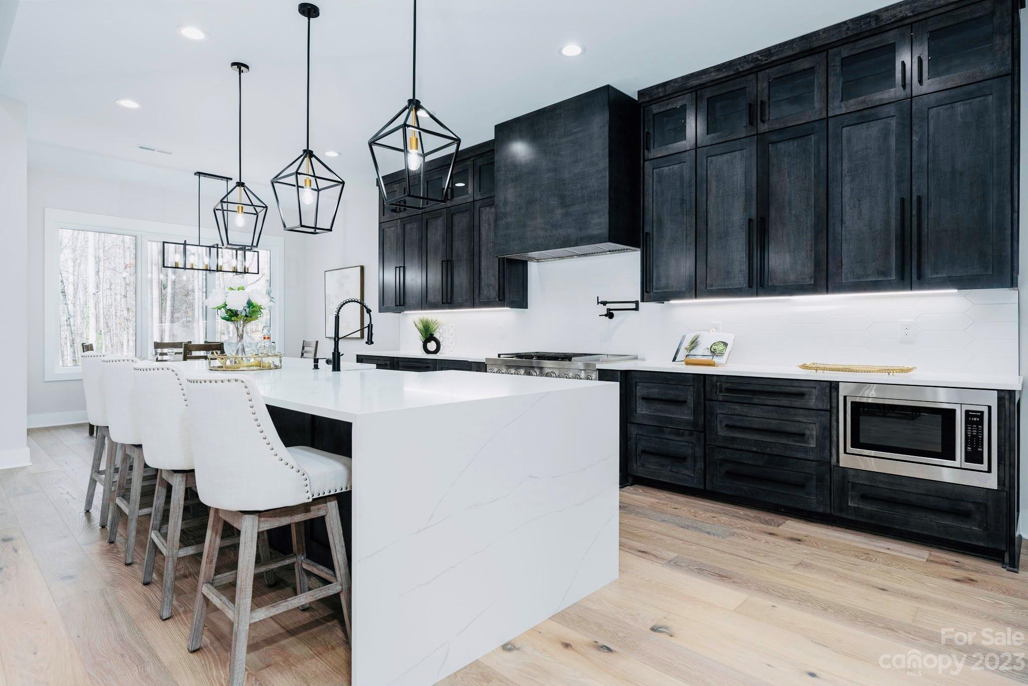 8527 Fieldstone Drive Terrell, NC 28682 - Photo 17 of 48 a kitchen with granite countertop a table chairs stainless steel appliances and cabinets