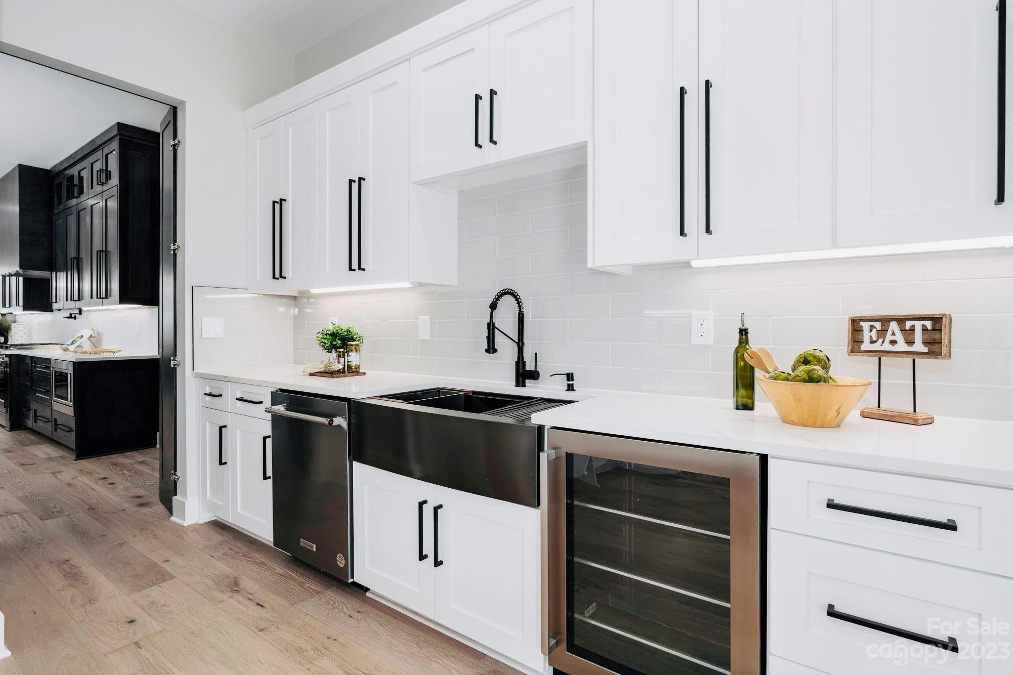 8527 Fieldstone Drive Terrell, NC 28682 - Photo 22 of 48 a kitchen with a sink dishwasher and white cabinets with wooden floor