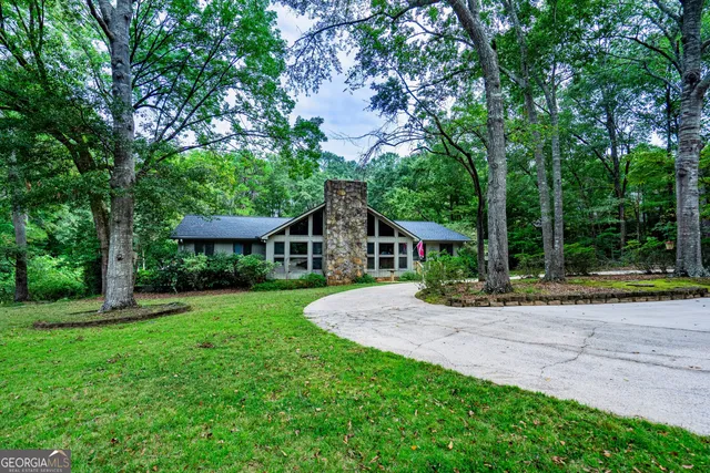 a view of a house with a yard and tree s