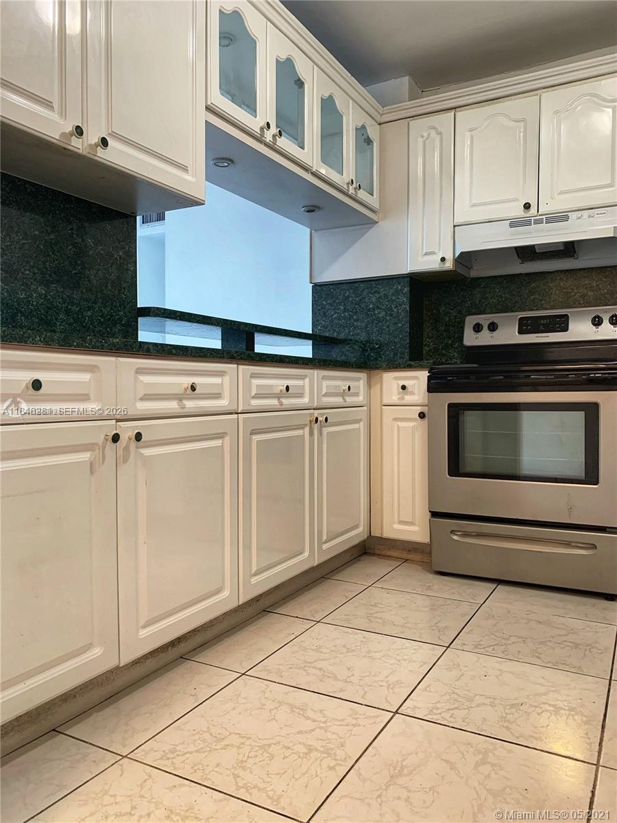 1325 West 68th Street, Unit 514 Hialeah, FL 33014 - Photo 8 of 20 a kitchen with cabinets and appliances